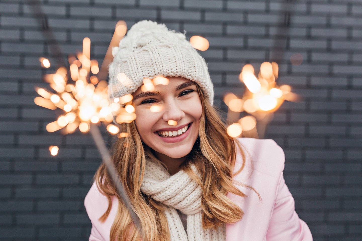 A young girl is dressed in a winter beanie coat, smiling..