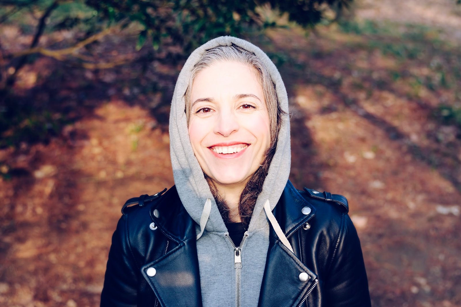 Beautiful woman face. Short hair. Smiling. Her upper teeth are visible. Someone who has had a Porcelain Lamina treatment.