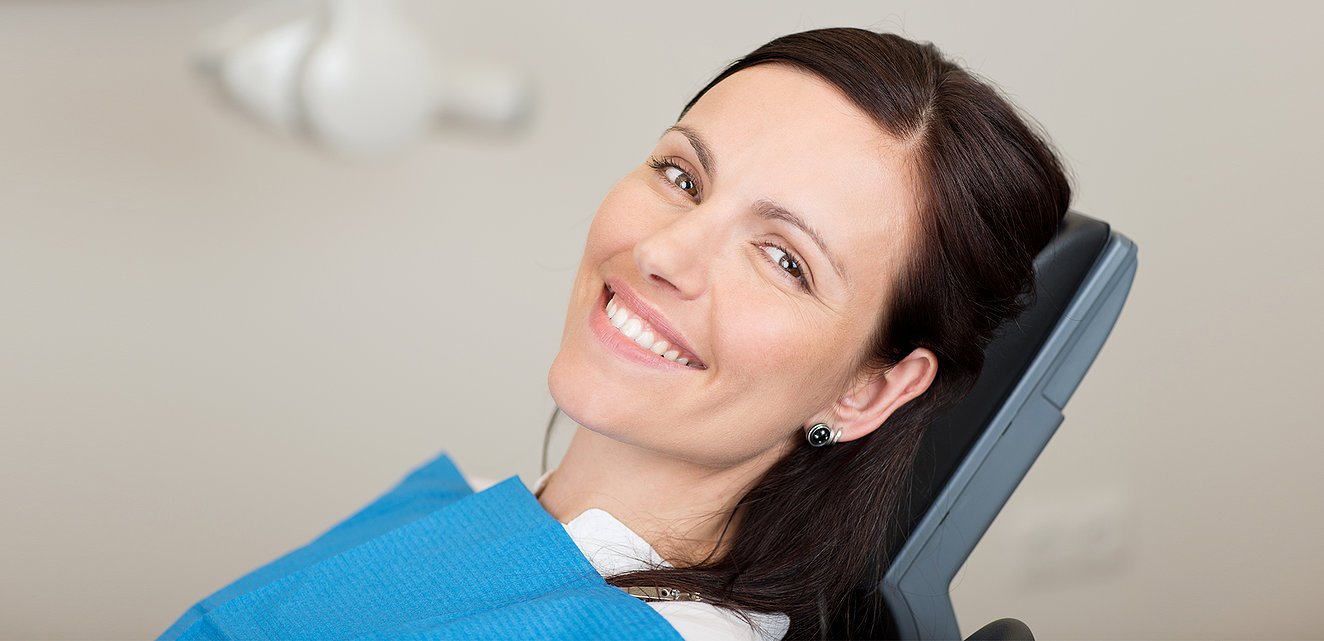 Beautiful woman sitting in dentist chair smiling.