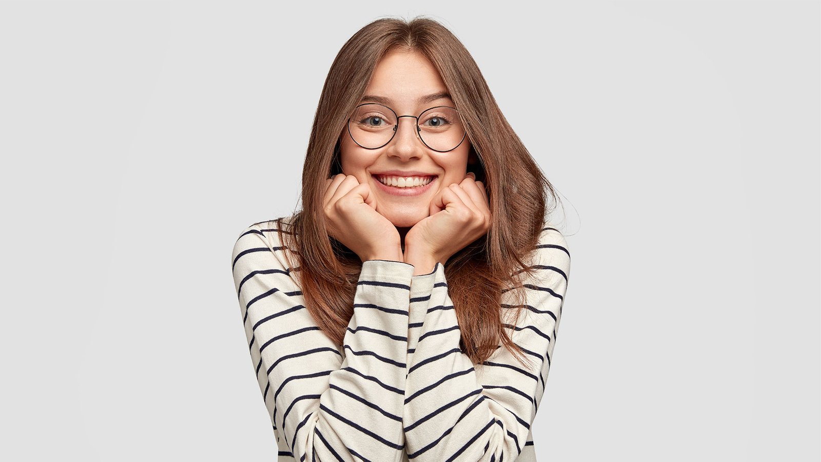 A student girl with glasses is smiling.