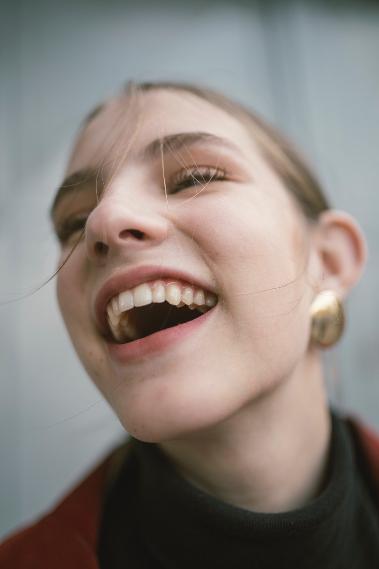 A girl who has had an implant treatment smiles. Her teeth look natural.