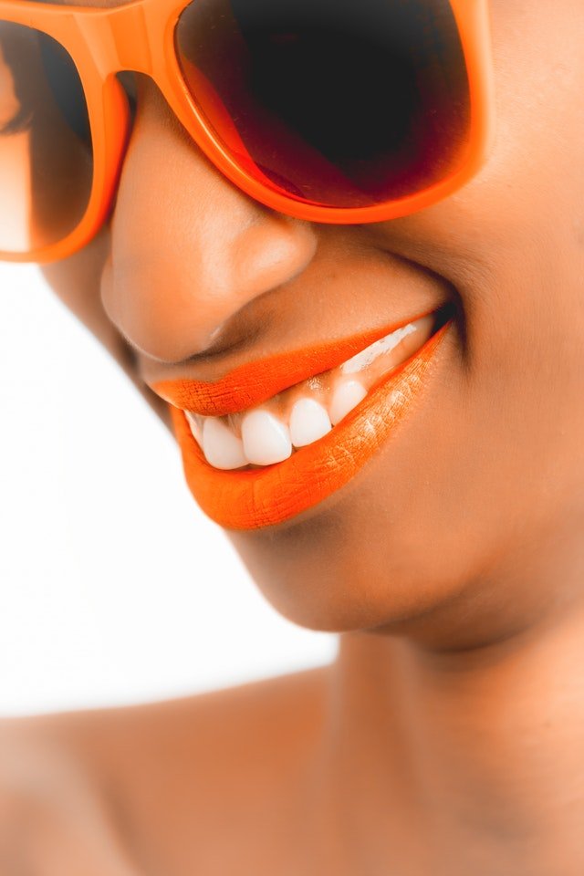 A young woman undergoing implant treatment. Smiling. Her teeth look white and shiny.