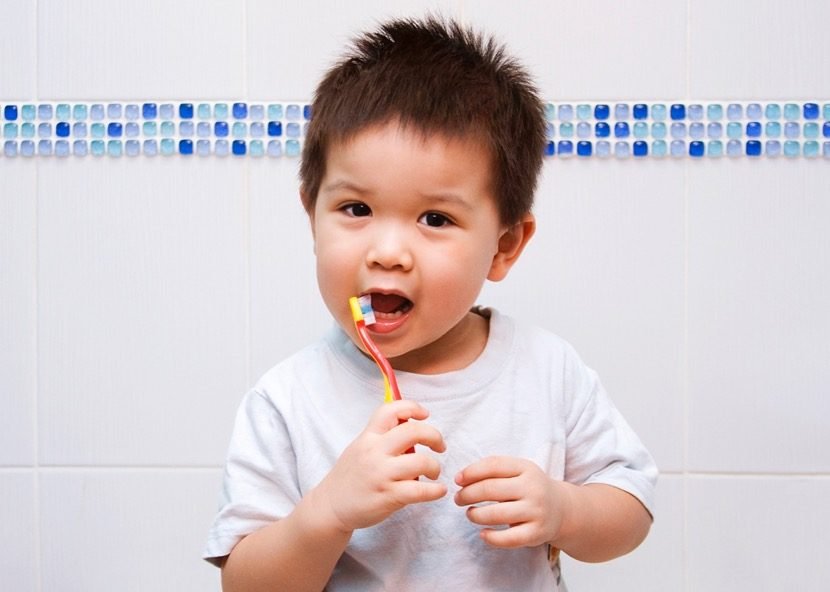 A boy brushing his teeth. About five years old.